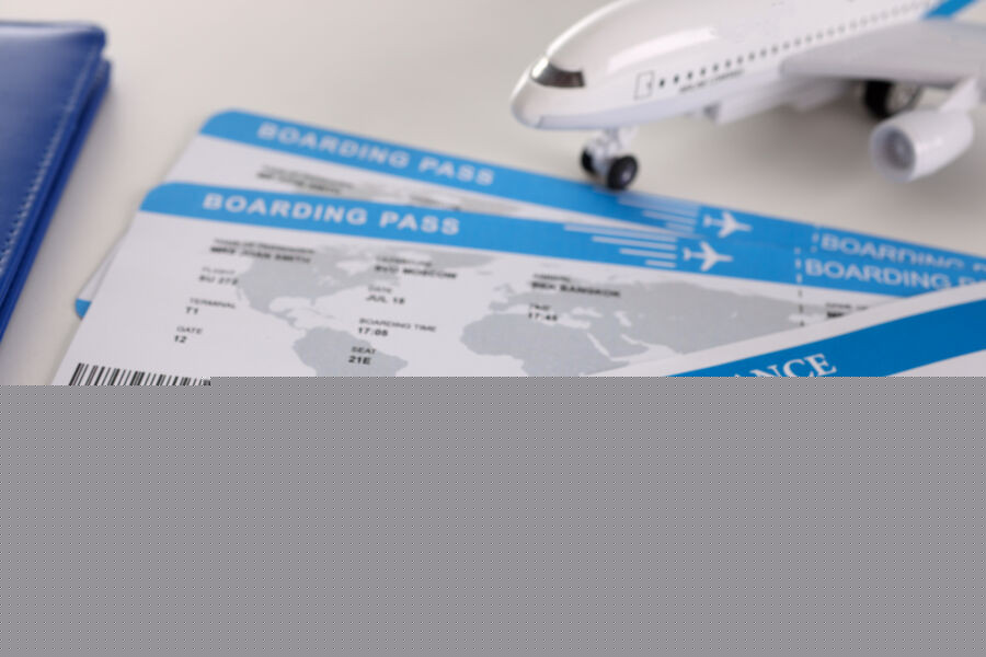 Airplane tickets and an empty travel insurance form with a pen, ready for information to be filled in