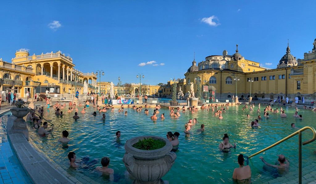 Crowds of people in the historic outdoor thermal baths in Budapest